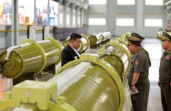 Кім Чен Ин оглядає ракети Hwasong-11 у складальному цеху.