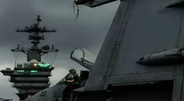 Американський моряк оглядає військовий літак на польотній палубі USS Abraham Lincoln